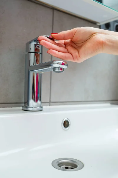 バスルームには銀製の蛇口が付いています 手のための液体石鹸で灰色缶 水道水をオンにし 個人的な手の衛生 — ストック写真