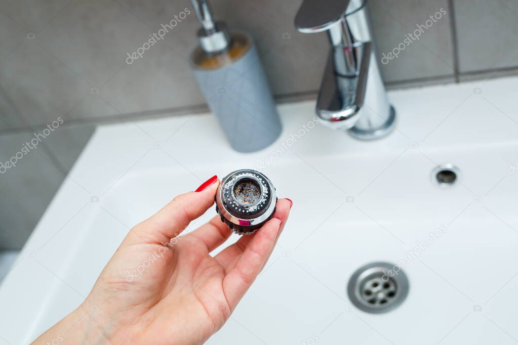 Rotary nozzle on the mixer to adjust the flow of water. White bathroom sink for washing hands