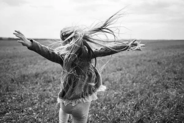 女の子の子供は畑の緑の草の上を走り晴れた春の天気子供の笑顔と喜び雲と青い空 — ストック写真