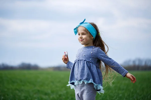 小さな女の子が走りジャンプフィールドの緑の草晴れた春の天気子供の笑顔と喜び雲と青い空 — ストック写真