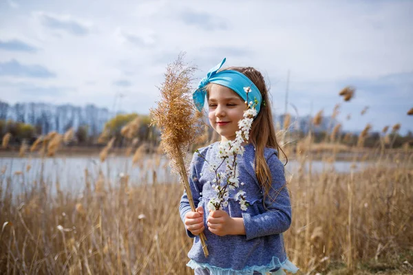 Criança Menina Mantém Juncos Secos Ramo Com Pequenas Flores Brancas — Fotografia de Stock