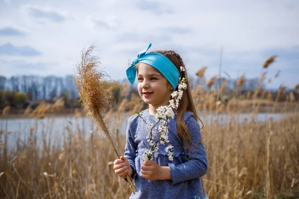 Küçük Kız Elinde Kuru Sazlıklar Ellerinde Küçük Beyaz Çiçekler Olan — Stok fotoğraf