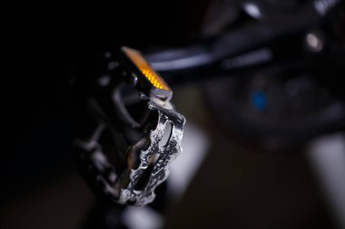 Sert ışığı olan bir bisikletin üzerinde siyah metal pedal. Bisiklet aksesuarları