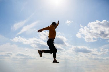 Adam, beyaz bulutlu mavi gökyüzünün arka planında serbest turist, güneşli bir gün, doğa ve insan özgürlüğü.