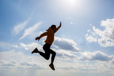 Adam, beyaz bulutlu mavi gökyüzünün arka planında serbest turist, güneşli bir gün, doğa ve insan özgürlüğü.