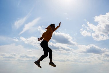Adam, beyaz bulutlu mavi gökyüzünün arka planında serbest turist, güneşli bir gün, doğa ve insan özgürlüğü.