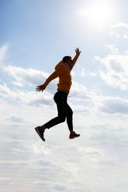 Adam, beyaz bulutlu mavi gökyüzünün arka planında serbest turist, güneşli bir gün, doğa ve insan özgürlüğü.