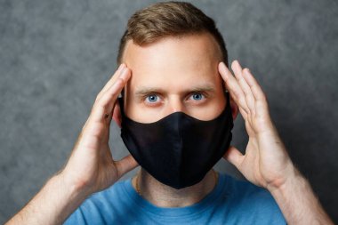 Siyah koruyucu maskeli genç adam virüslere karşı. COVID 19