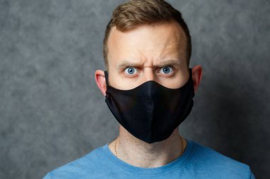 Siyah koruyucu maskeli genç adam virüslere karşı. COVID 19