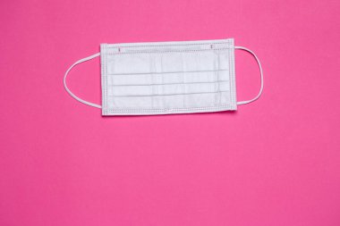 Renkli bir arka planda virüse karşı korunmak için beyaz tıbbi maske.