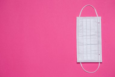 Renkli bir arka planda virüse karşı korunmak için beyaz tıbbi maske.