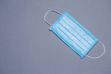 Renkli bir arka planda virüse karşı korunmak için mavi tıbbi maske.