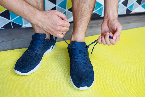 guy man shoes sport shoes standing on a yellow rug for sports, training at home