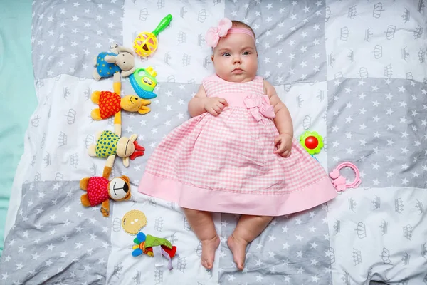 Menina Meses Está Deitada Cama Bebê Vestido Rosa Uma Faixa — Fotografia de Stock