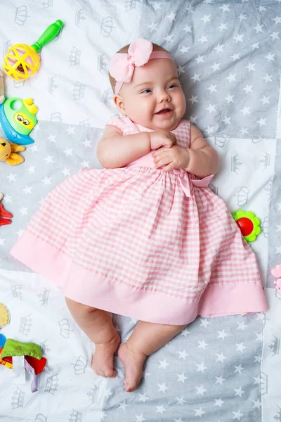 Menina Meses Está Deitada Cama Bebê Vestido Rosa Uma Faixa — Fotografia de Stock