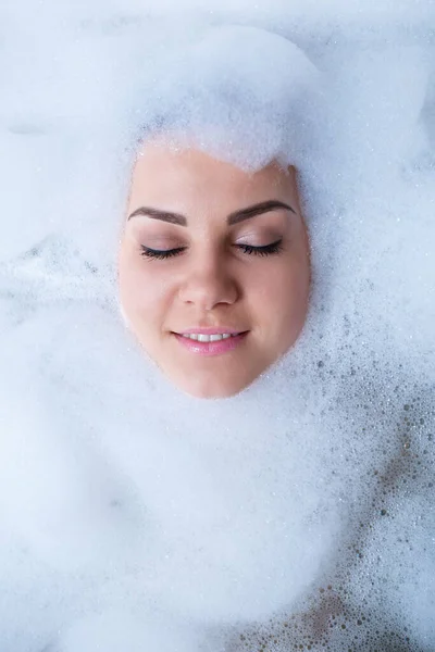 一个穿着浴盆的女孩的肖像和她的脸周围的白色泡沫 不同的情感 不同的表情 不同的女人的笑容 — 图库照片