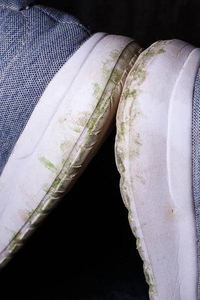 地面や草から汚れたソールを持つグレーの男性のスニーカー ジョギングやスポーツのための靴 — ストック写真