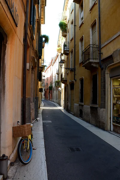 Bicicleta con cesta de mimbre en la calle estrecha de Verona, Italia . — Foto de Stock