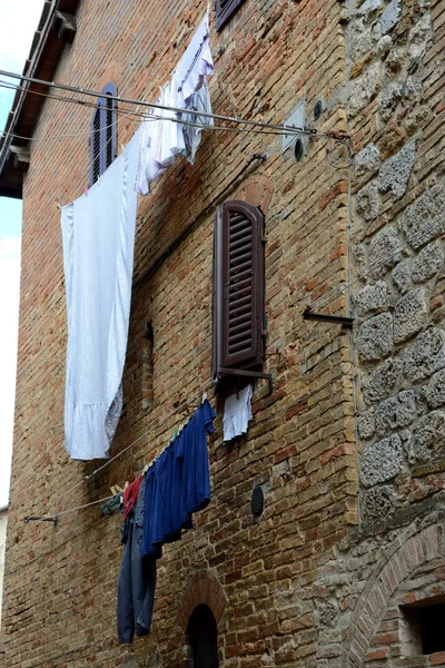 Ropa colgada en la pared de ladrillo y piedra — Foto de Stock