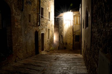 Narrow street at night in San Gimignano city in Tuscany, Italy. clipart