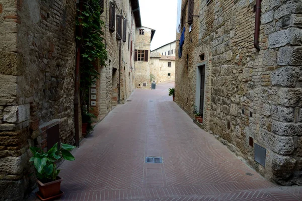 Úzká ulice v San Gimignano město v oblasti Toskánsko, Itálie. — Stock fotografie
