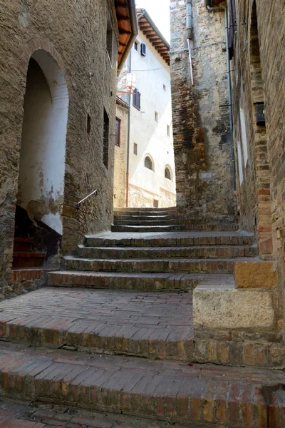 Узкая улица и лестница в Сан-Джиминьяно в Тоскане, Италия . — стоковое фото