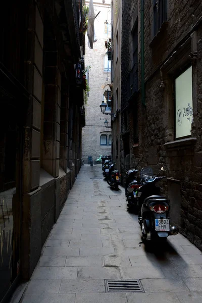 Scooters en estrecha calle oscura en Barcelona ciudad, España — Foto de Stock