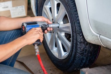 Profesyonel araba tamircisi el, oto tamir servisinde uzmanlık ve hız ile araba tekerleği değiştirme araçları kullanın.