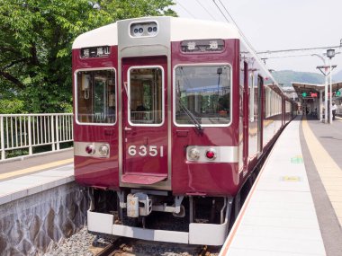 Japonya 'daki yerel tren Katsura İstasyonu ile Arashiyama İstasyonu arasında 25 Mayıs 2019' da Osaka Japonya 'daki Arashiyama İstasyonu' ndan turistleri almak için bekleyen 6351 numaralı tren arasında hareket eder..