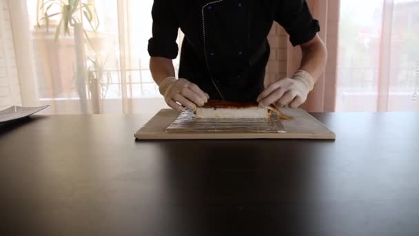 Chef de sushi masculino pone anguila ahumada en un rollo de arroz.Sushi proceso de fabricación. Rolls el rollo de sushi — Vídeo de stock