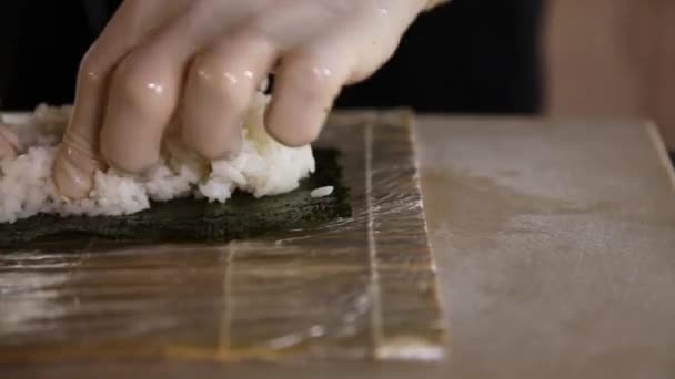 Närbild av sushi master sprider ris på Nori.Sushi tillverkningsprocessen.Kockar händer — Stockvideo