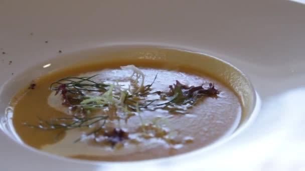 Гарбузовий суп з пюре. ресторанна тарілка. крупним планом. камера рухається навколо цього праворуч — стокове відео