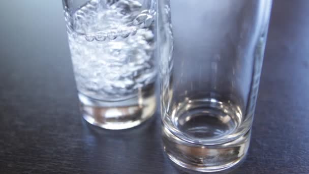 Dos vasos se llenan sucesivamente con agua limpia. primer plano — Vídeos de Stock