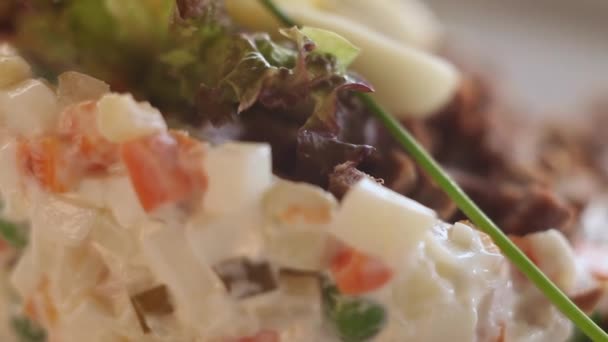 Zeer close-up Russische salade.Macro.Camera beweegt rond een bord. — Stockvideo