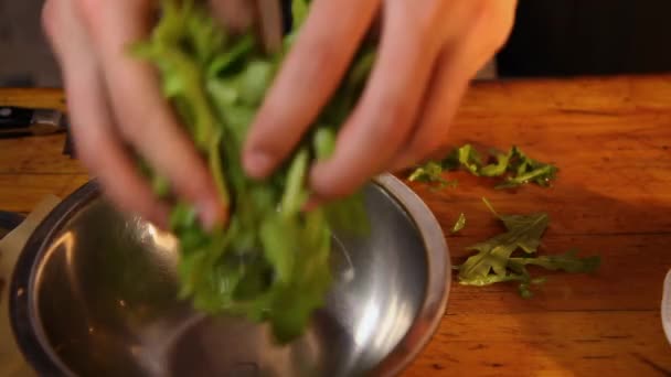 Il cuoco taglia la rucola, la mette in una ciotola, aggiunge fragole, pomodorini, mozzarella e la mescola. . — Video Stock