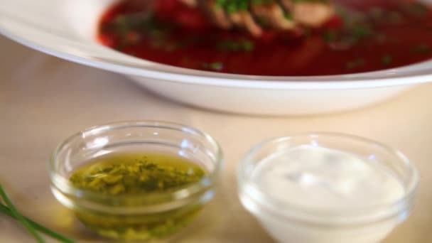 Primo piano del processo di innaffiamento con olio di aglio borscht con carne e erbe finemente affettate.Borsch . — Video Stock