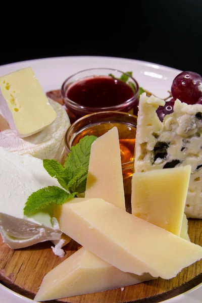 Peynir tahtası. Parmesan, mavi peynir, naneli, ballı, reçelli, üzümlü, ahşap tahtada servis edilen camembert peyniri..