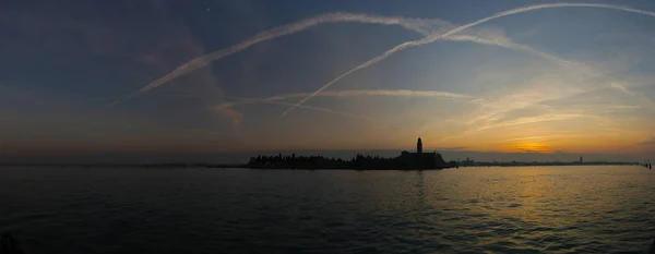 Gün batımında Venedik 'teki San Michele adası manzarası. Gökyüzünde uçak izleri var..