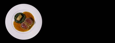 Ispanaklı sığır eti ve kızarmış patates. Siyah bir arka planda izole edilmiş. Panorama afişler için. Kopyalama spazmı..