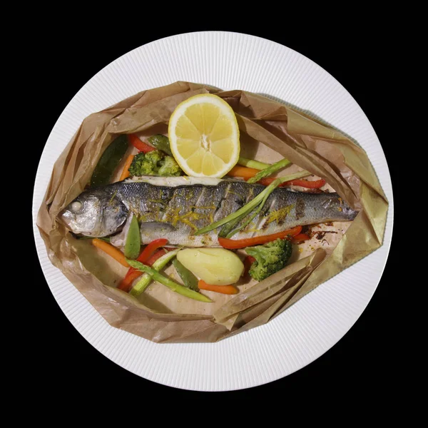 Kağıt üzerinde servis edilen sebzeli ve limonlu ızgara deniz kabuğu..