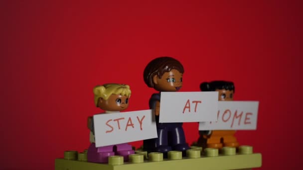 Lego muži držící transparenty STAY AT HOME. — Stock video