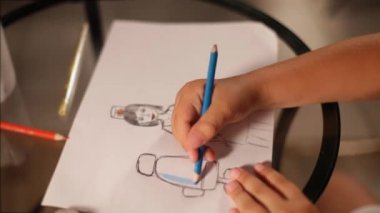 CHOVID-19 salgınının karantinası sırasında Childs elinde mavi kalemle kadın doktor çiziyor..