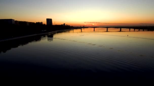 Vista aérea del puente sobre un río ancho al atardecer.4k . — Vídeos de Stock