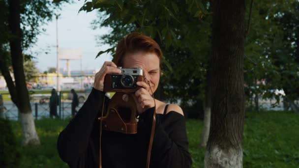 Červenovlasá dívka fotografování podle vintage camera. — Stock video
