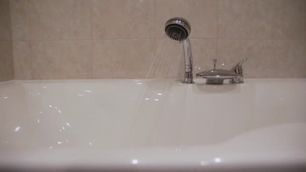 Вода льется из душевой головы в ванну . — стоковое видео