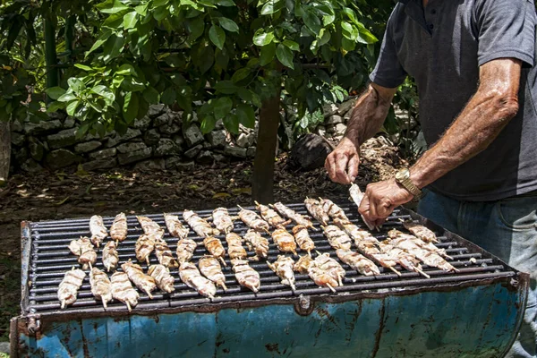 close up of man grilled fishes on fire