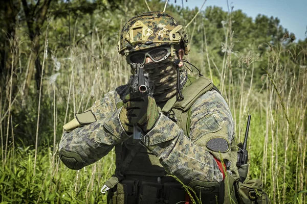 Voják na bitevním poli míří pistolí — Stock fotografie