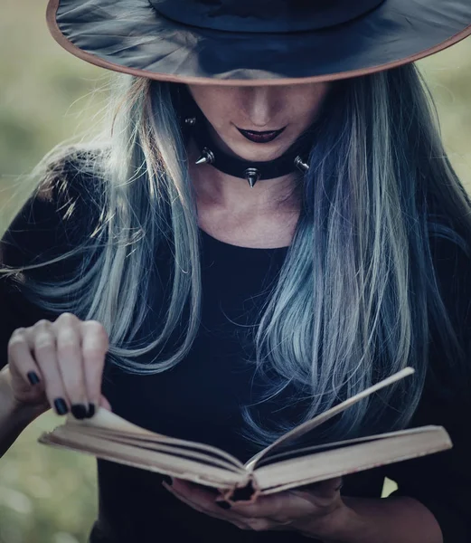 Witch reading a book of magic — Stock Photo, Image