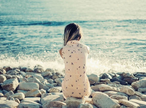 小石のビーチで休んで若い女性 — ストック写真