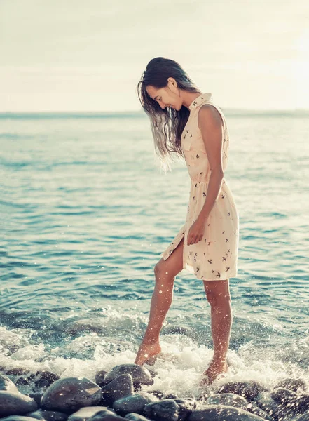 Ευτυχισμένη γυναίκα που περπατά στην παραλία με βότσαλα — Φωτογραφία Αρχείου